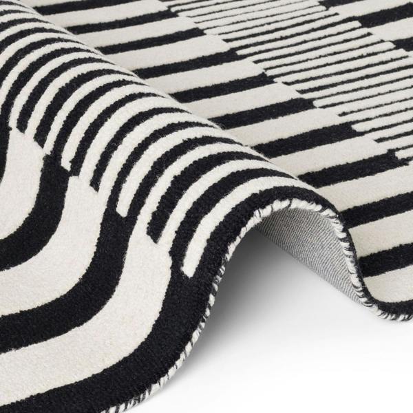 Close-up of a black and white striped rug with geometric patterns.