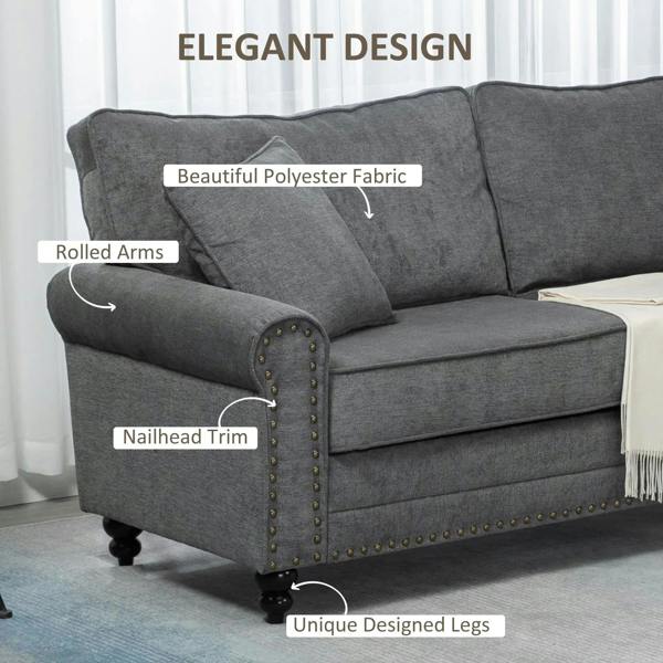 Grey fabric sofa arm with rolled design, nailhead trim, and dark turned legs