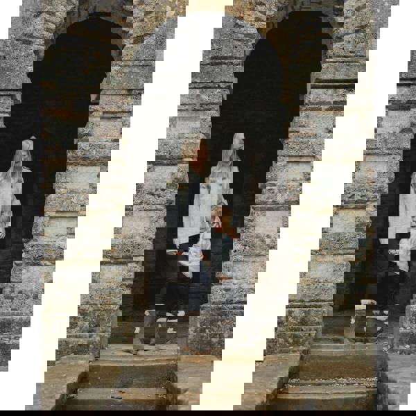 Hush Puppies Megan Womens Tall Hi Zip Up Mid Calf Boots, cozy gray winter boots with faux fur trim, worn by a woman and a young girl standing near a stone archway in a scenic outdoor setting.