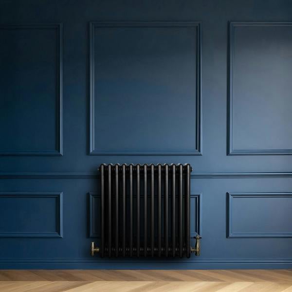 Traditional black 4 column radiator against a deep blue wall, featuring sleek lines and a classic design, perfect for vintage decor