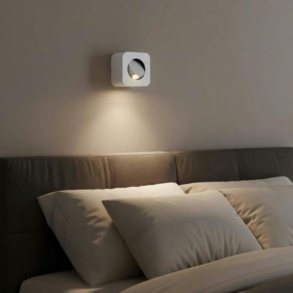 white wall mounted bedside lamp mounted on a wall above a bed in a modern bedroom