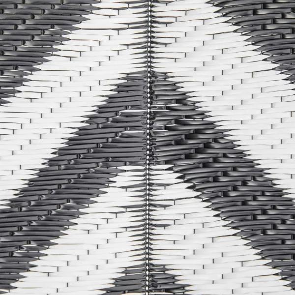Black and white woven rug with Greek key pattern, close-up textured strands.
