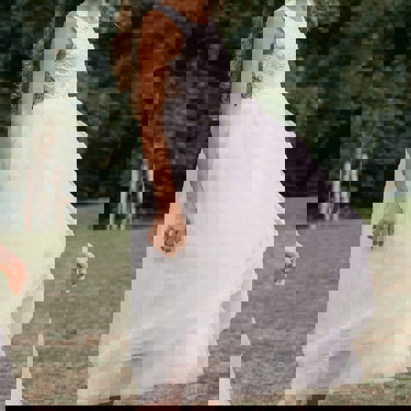 girl wearing a white dress with a lace top in an outdoor setting