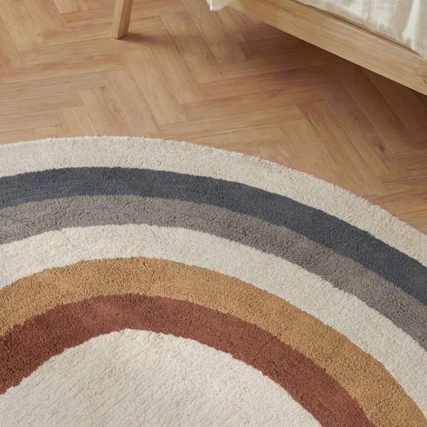 Round rug with multicolored stripes on a wooden floor