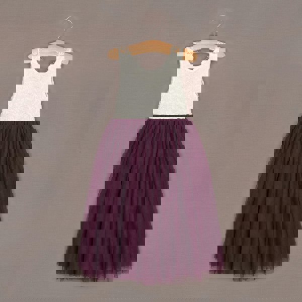 White lace top and purple tulle skirt dress on a hanger against a brown background