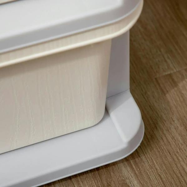 Bottom corner close-up of three-tier kids storage cabinet with gray base