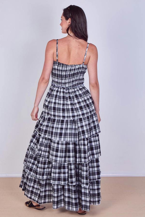 Woman wearing a black and white checkered dress against a plain background