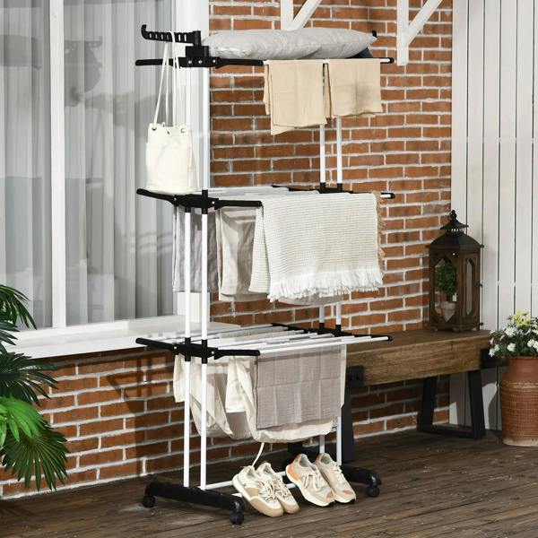 Black 4-tier drying rack with hanging bars holding folded clothes and shoes