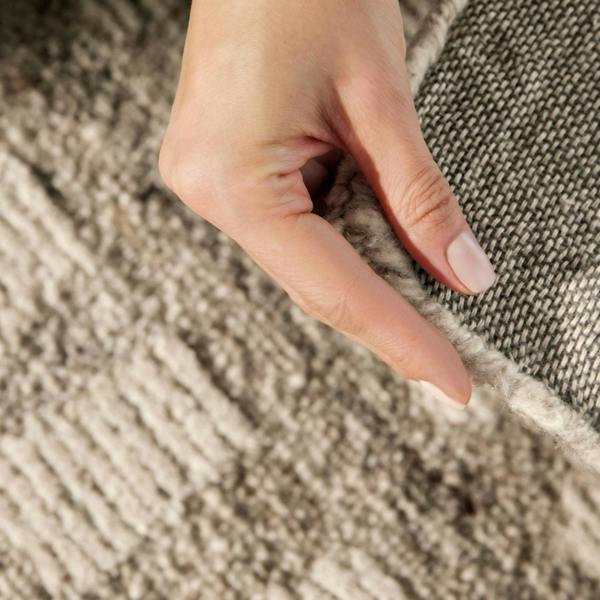 Close-up of a hand touching textured fabric