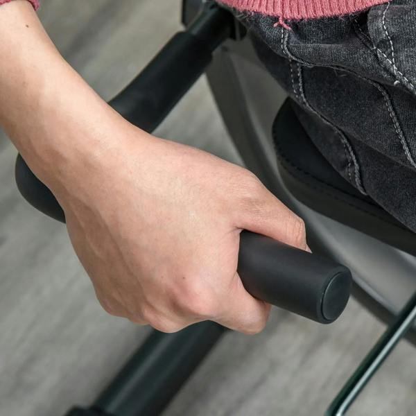 Close-up of a hand gripping a black arm handle on a recumbent exercise bike