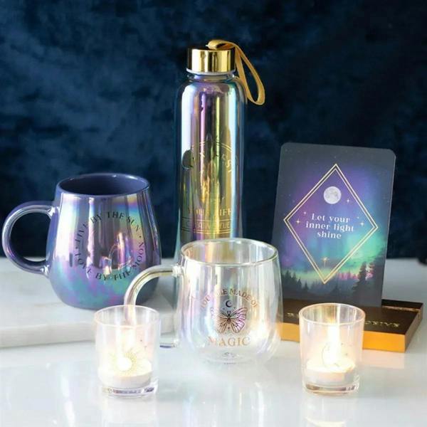 Iridescent glass votive cups with gold moon and sun motifs, lit candles