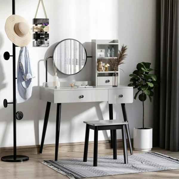 Gray vanity dressing table set with round mirror, open shelves, and matching stool.