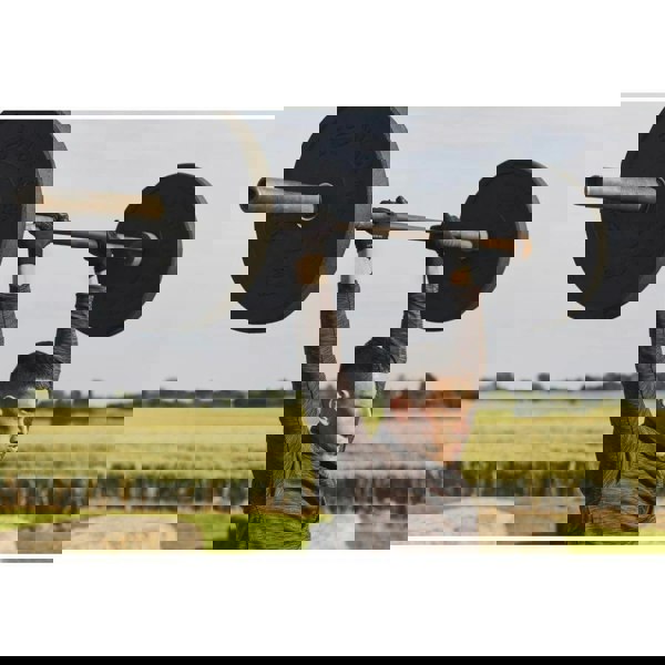 Man performing a shoulder press wearing adidas Full Finger Essential Gloves 