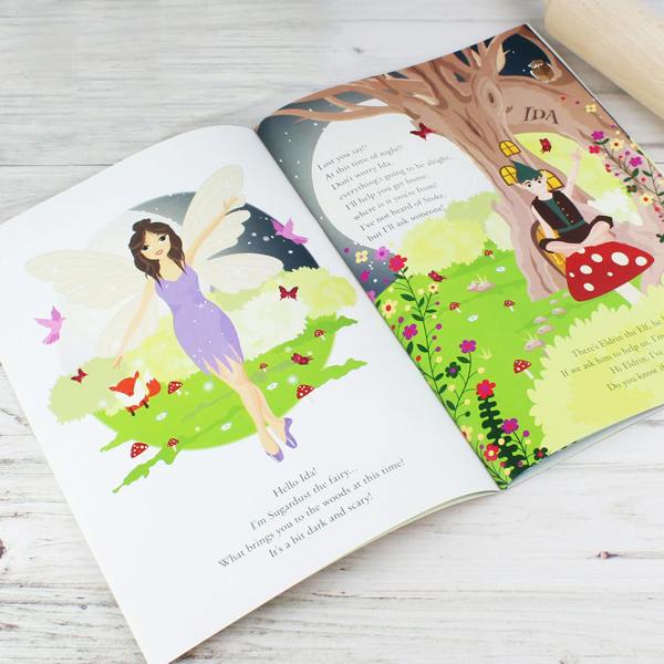 Open view of the Personalised Fairy Baking Adventure storybook showing Sugardust the Fairy introducing herself to Ida alongside Eldrin the Elf sitting by a tree with IDA carved into it
