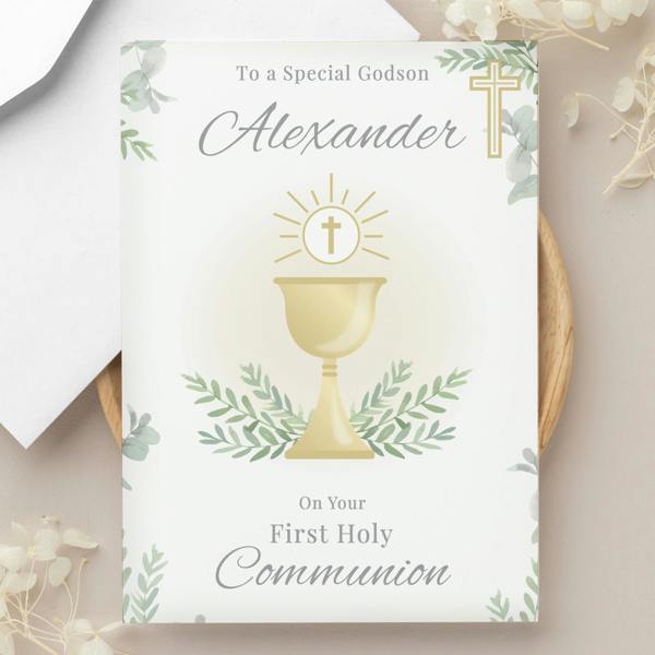 A personalised First Holy Communion card printed with "To a Special Godson Alexander" featuring an illustrated gold chalice and green leaves.