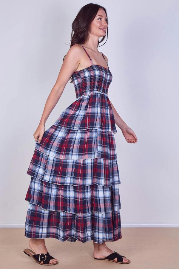 Woman wearing a plaid dress against a plain background