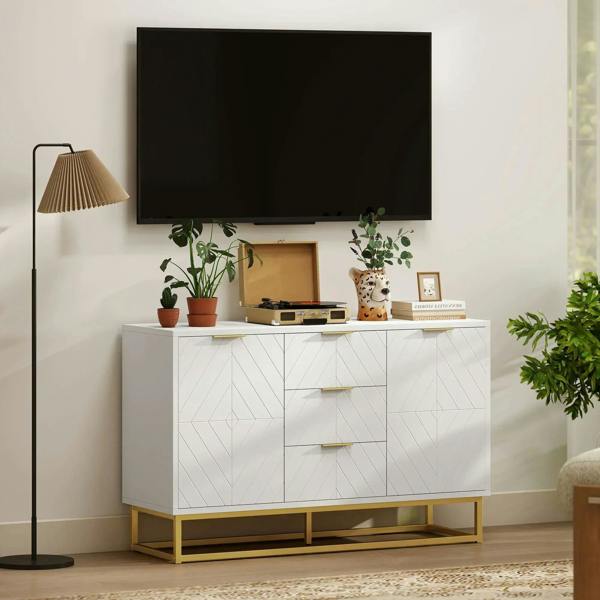 White sideboard cabinet with 3 drawers, gold pulls, geometric doors, raised base.