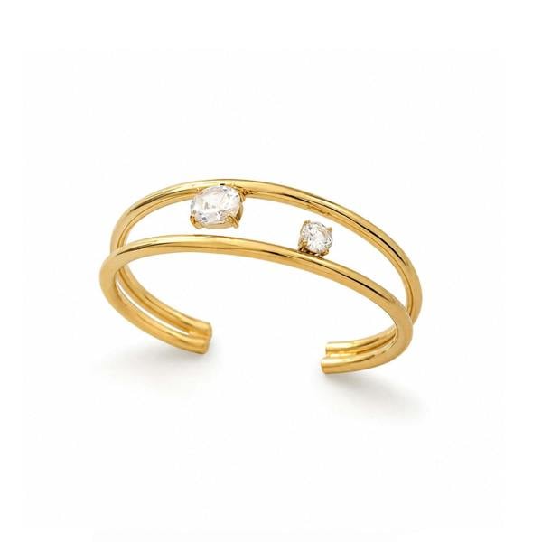 A gold open cuff ring featuring two small bezel-set clear stones, displayed on a clean white background.