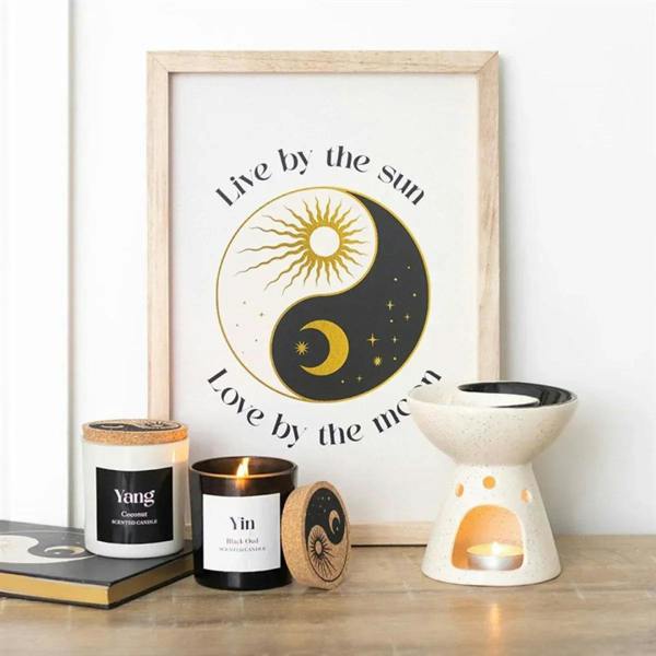 Two Yin-Yang candle jars plus a small ceramic burner with a lit flame