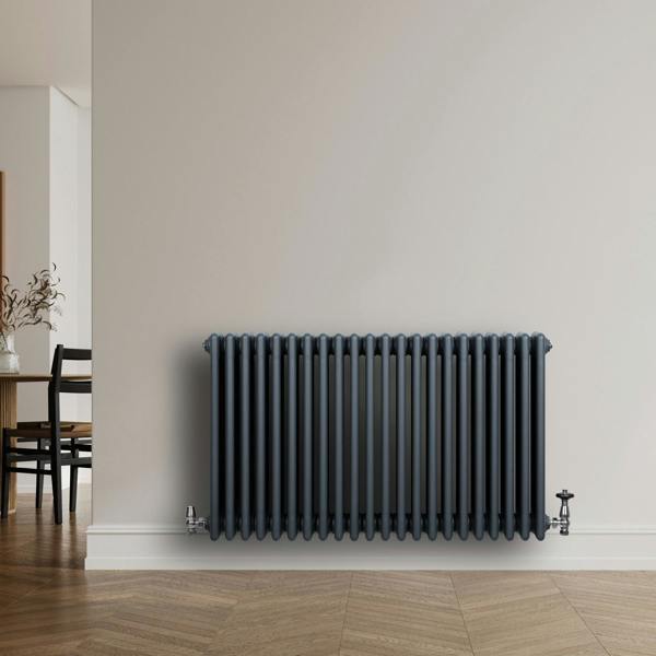 Traditional 4 column radiator in anthracite grey, featuring a sleek design and smooth finish, mounted on a light wall in a modern room