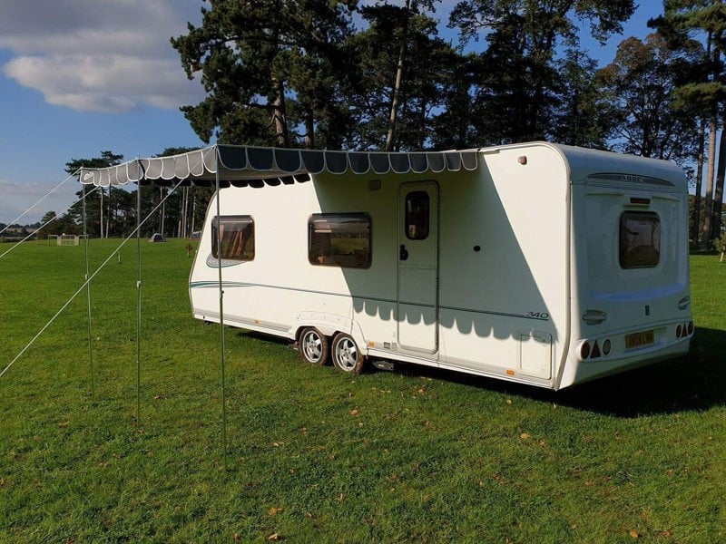 An image of the Charcoal Caravan Sun Shade Canopy from OLPRO attached to a caravan.