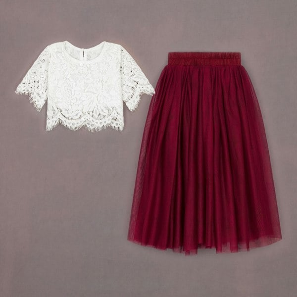 White lace top and red tulle skirt on a gray background
