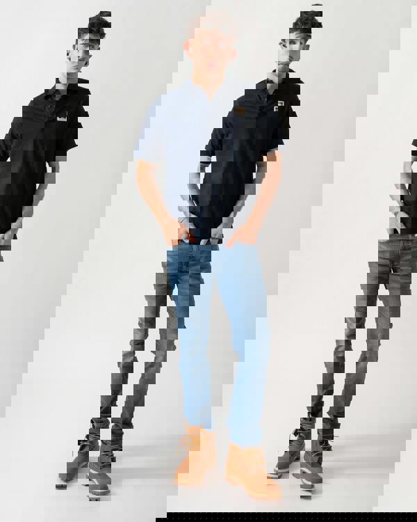 full length shot of a model wearing an Aquascutum Mens Stretch Piquet Badge Polo Shirt in Navy 11