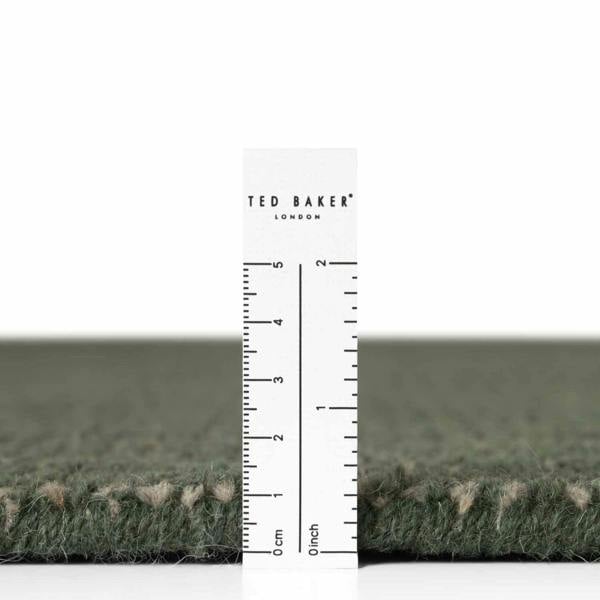 Green carpet sample with a ruler and 'Ted Baker London' branding