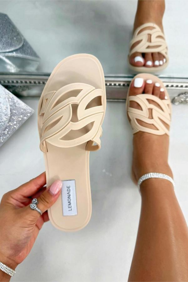 Beige sandals with a brand label on a white surface