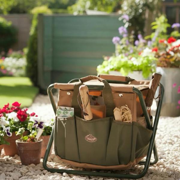 Portable garden tool stool with canvas storage bag, filled with hand tools and sitting on a gravel path.