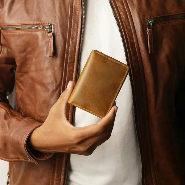 Tan leather Mayfair 2511 cardholder held in hand, highlighting its sleek and minimalist design.