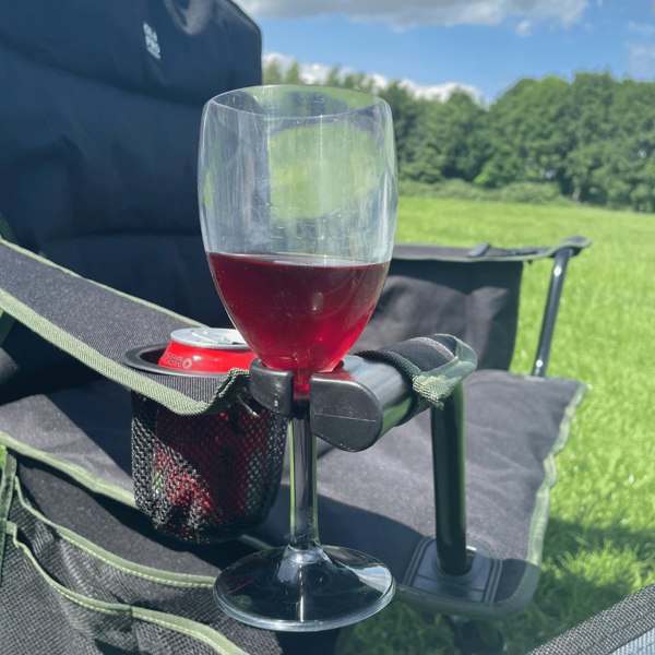 An image of a glass of wine being stowed in the wine glass holder of the Henwick Padded Folding Camp Chair - Black & Green from OLPRO outside of a tent.