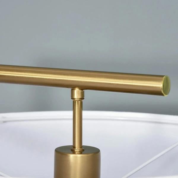 Gold lamp pole with round base and white drum shade top close-up