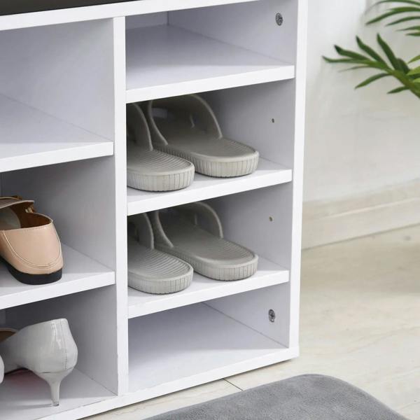 White shoe rack with dark cushioned top and open cubbies holding sneakers and heels