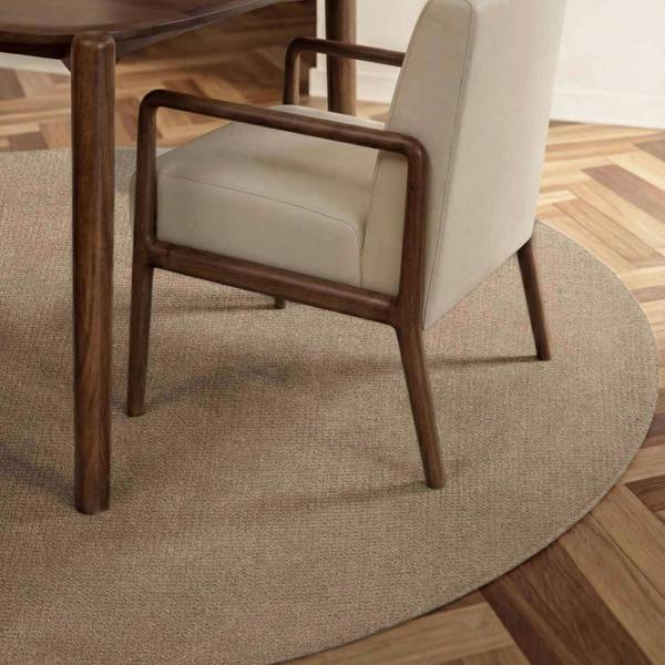 Chair with wooden frame and beige cushion on a round beige rug