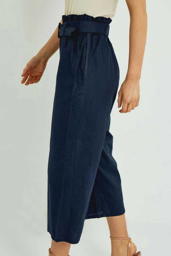 Navy blue wide-leg pants with a belt worn by a person on a light gray background
