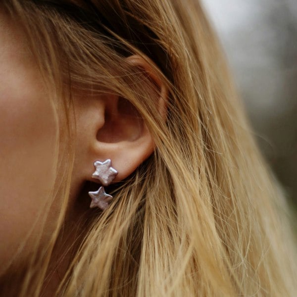 A model wearing star pearl silver ear jacket earrings.