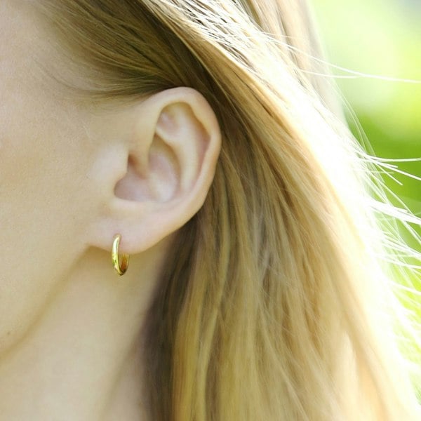 Close up of an ear with small hoop earring.