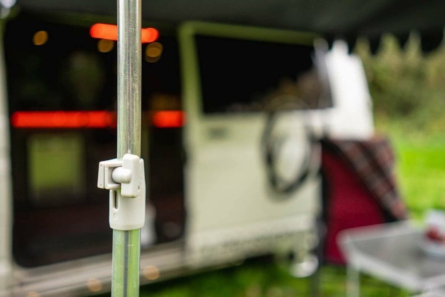 A closeup of the adjustable mechanism for the Orange and Brown Campervan Canopy from OLPRO with a VW T5 Campervan in the background.