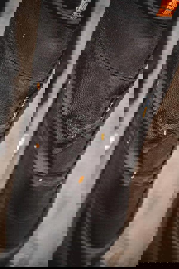 WorkTough Mens Cargo Stretch Fit Cordura Work Trouser Fleece Jogger, close-up view of black durable cargo work pants with multiple pockets and orange stitching details.