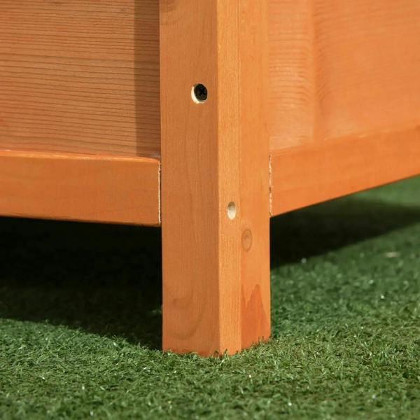 Close-up of yellow wooden kennel corner on legs, showing base and side panel seams