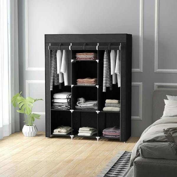 Black fabric wardrobe with hanging rails and shelves, open doorway with folded and hanging clothes.
