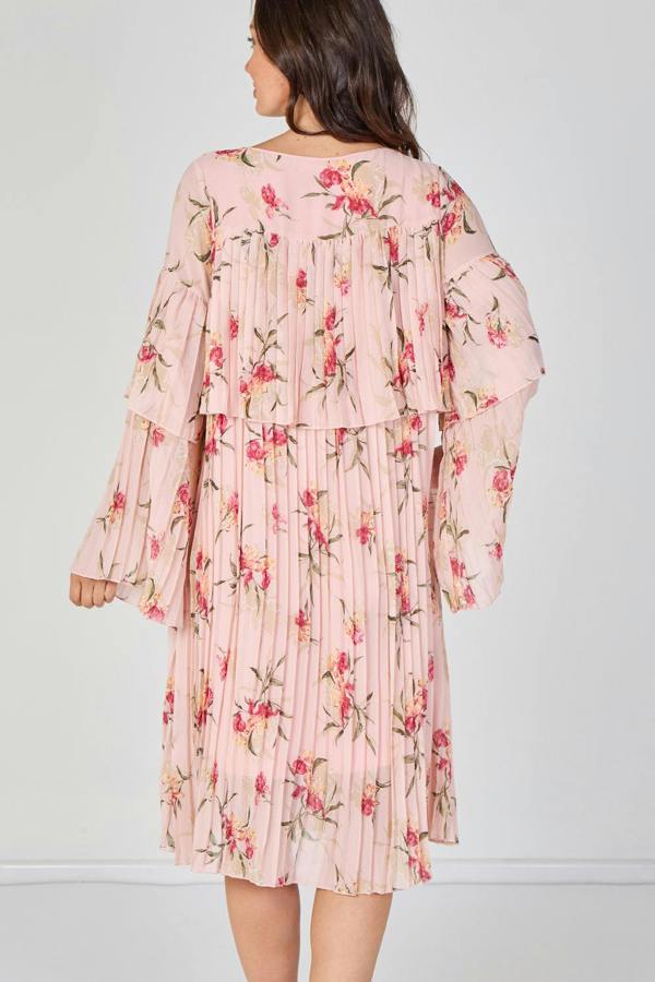 Woman wearing a pink floral dress against a white background