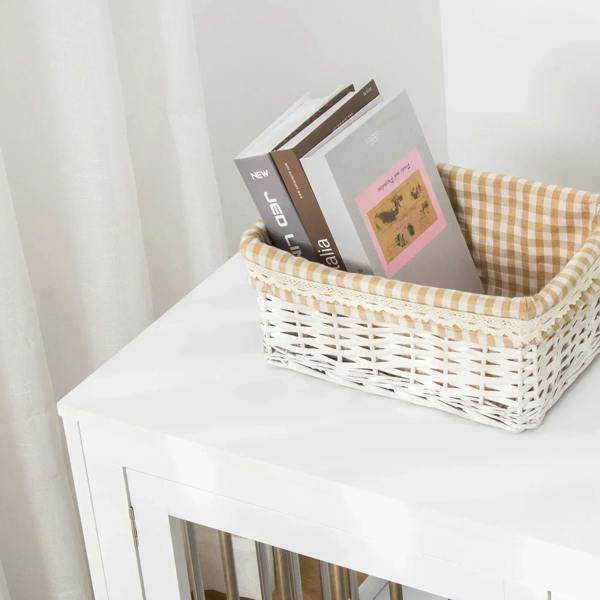 White dog cage and side table top surface with wicker bin beside the metal-bar door