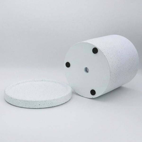 Two cylindrical concrete blocks with black bolts on a light gray background