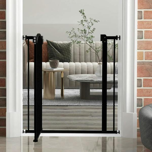 Black adjustable pet gate in an open doorway, vertical bars and bottom feet on tile floor