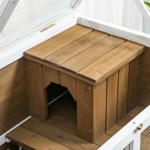 Brown wooden hutch interior with wooden platform, doorway, and lower ramp section
