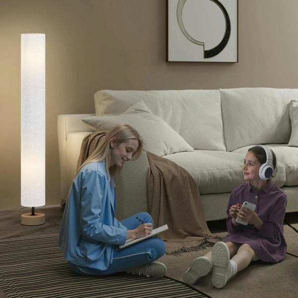 Grey linen floor lamp with wooden base beside couch, lit for reading