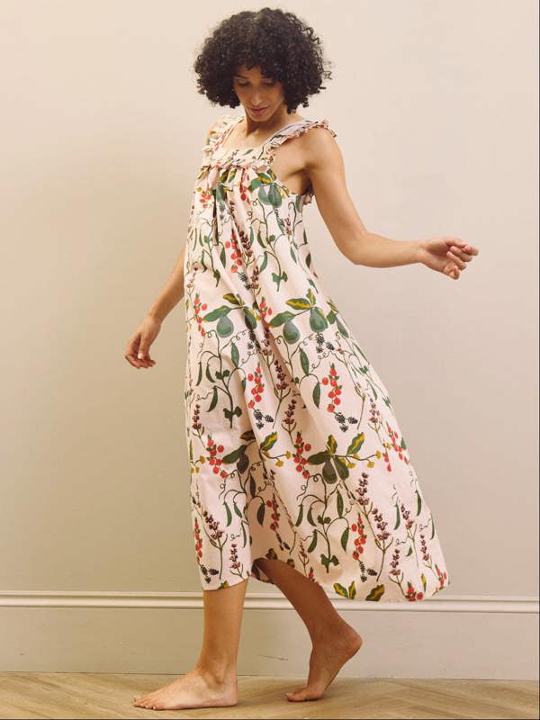 Woman wearing a floral & Pear night dress against a plain background
