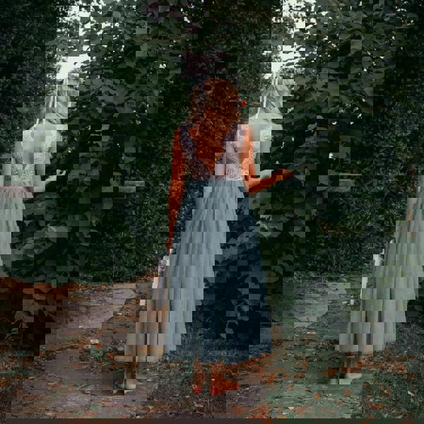 Girl in a sage green  dress standing in a garden